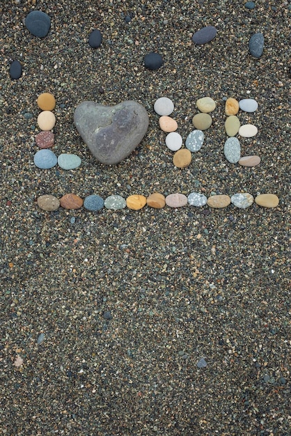 Słowo miłość z kamieni na piaszczystej plaży?