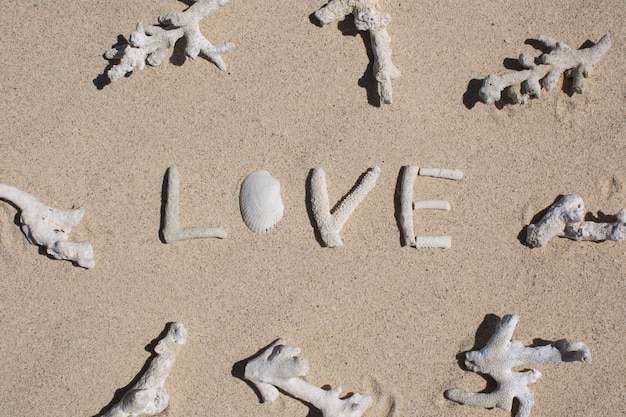 Słowo Miłość z korali na piasku tropikalnej plaży