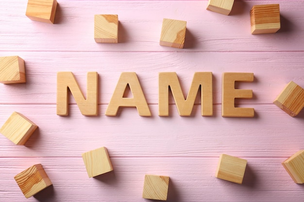 Zdjęcie słowo nazwa i drewniane kostki na kolorowym tle koncepcja wyboru imienia dziecka