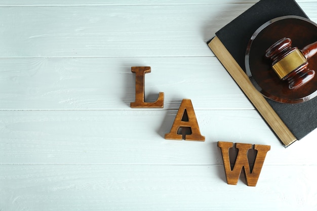 Zdjęcie słowo prawo z młotkiem sędziów i książką prawną na drewnianym tle