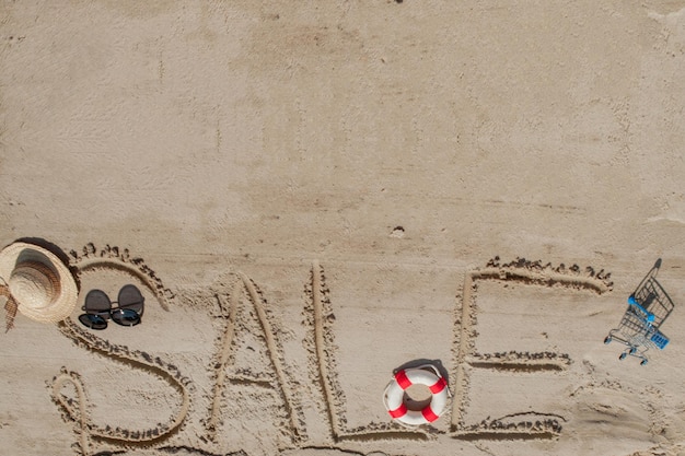 Słowo sprzedaż jest namalowane na piasku Plaża w tle Widok z góry Koncepcja letnich letnich wakacji kanikkuly wakacje