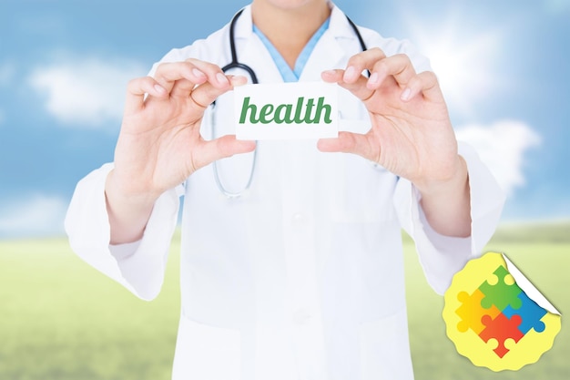 Słowo zdrowie i lekarka trzyma kartę przeciw pogodnemu zielonemu krajobrazowi