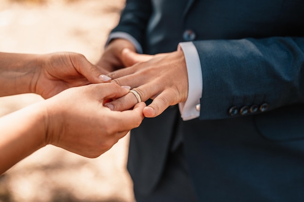 Ślubne obrączki zaręczynowe Małżeństwo wymienia obrączki podczas ceremonii ślubnej Pan młody założył pierścionek na palec swojej ukochanej żony