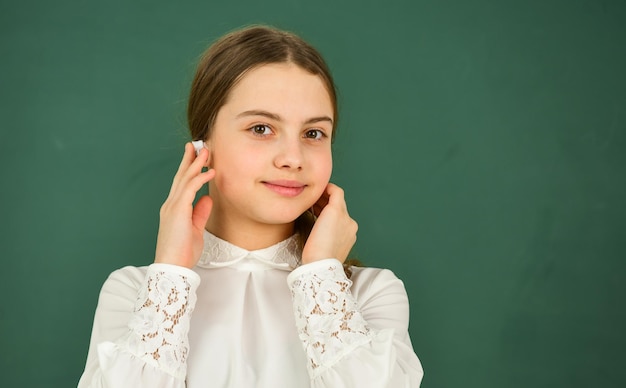 Słuchanie książki audio Tłumaczenie audio Dziewczyna w słuchawkach słucha muzyki Koncepcja uczenia się dźwięku Nauczanie domowe Edukacja online Studentka dziewczyna w słuchawkach na tablicy tło Kopia przestrzeń