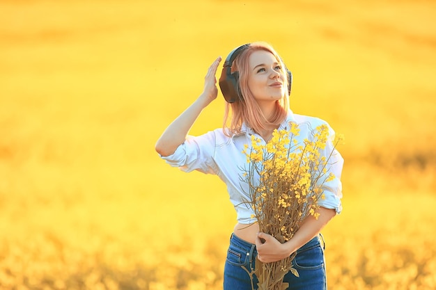 słuchawki audio lato dziewczyna muzyka w polu kwiatów, młoda kobieta wiosna