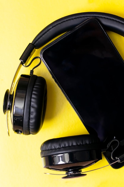 Zdjęcie słuchawki i telefon na żółtym tle