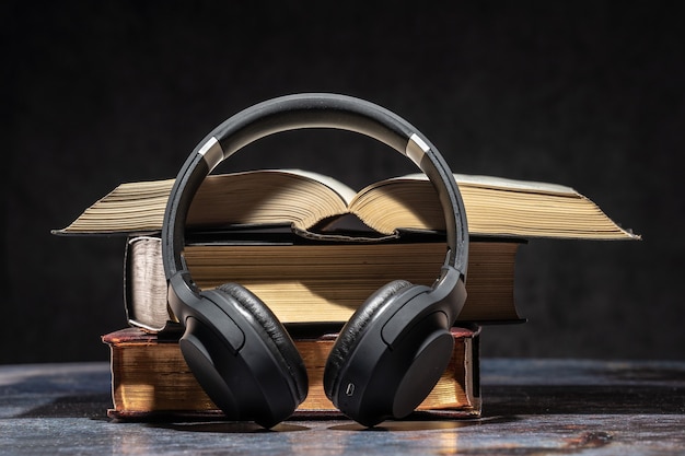 Zdjęcie słuchawki leżące obok starych książek. koncepcja książki audio.