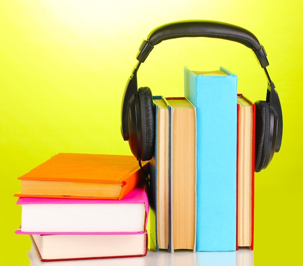 Słuchawki na książkach na zielonym tle