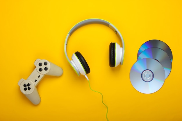 Słuchawki stereo z gamepadem, płyty cd na żółtej powierzchni