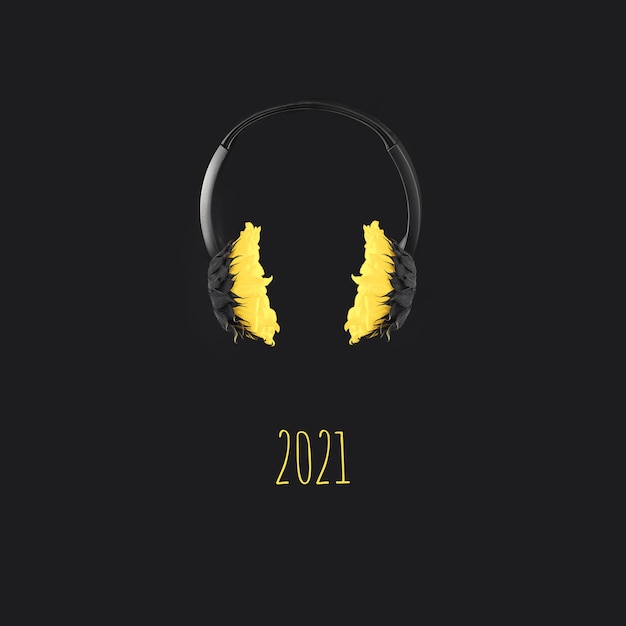 Zdjęcie słuchawki z żółtymi słonecznikami unoszą się w powietrzu na szarym tle, kolorystyka roku 2021