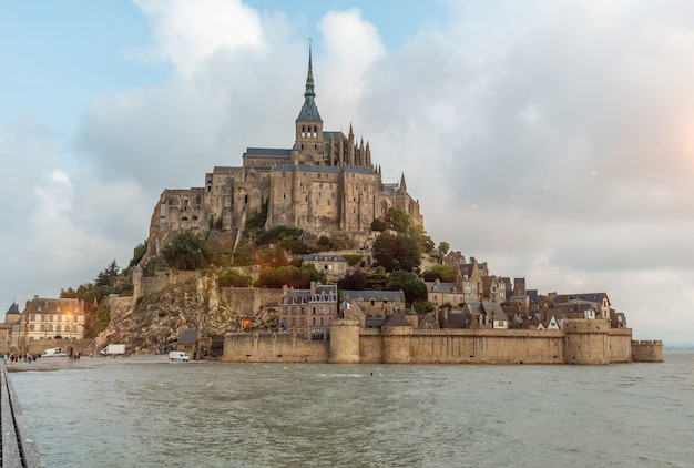 Słynne opactwo Mont Saint-Michel o wschodzie słońca podczas przypływu w departamencie Manche, region Normandii, Francja