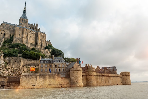 Słynne opactwo Mont Saint-Michel o wschodzie słońca podczas przypływu w departamencie Manche, region Normandii, Francja