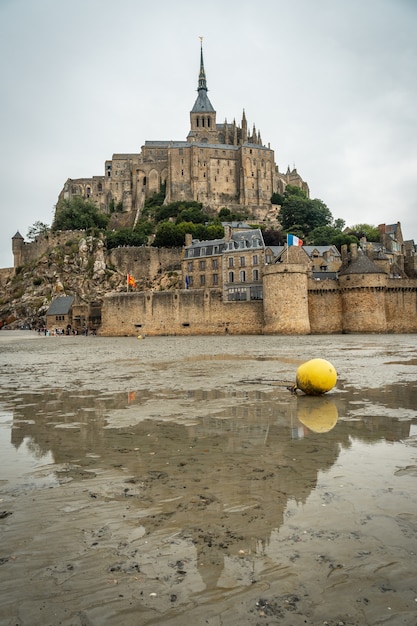 Słynne opactwo Mont Saint-Michel odbite podczas odpływu na plaży i kręgielnia dla łodzi, region Normandii, Francja