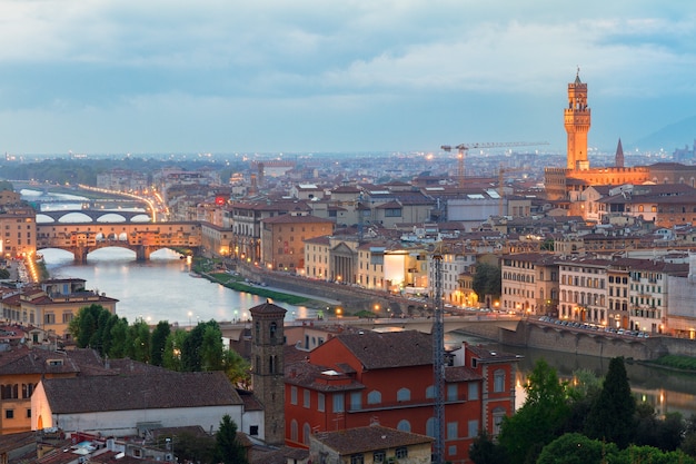 Słynny most Ponte Vecchio i stare miasto nocą, Florencja, Włochy