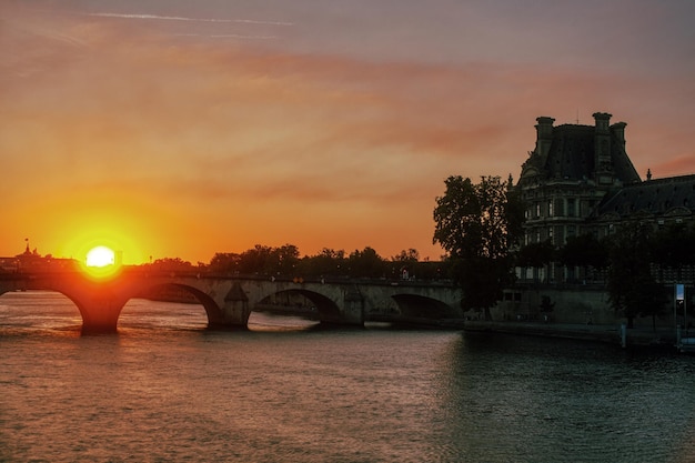 Słynny most zwany Pont Royal i Luwr o zachodzie słońca Paryż