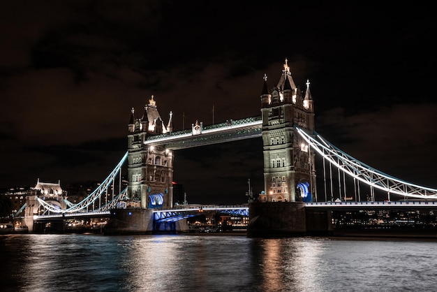 Słynny widok Tower Bridge łączący Londyn z Southwark nad Tamizą w Wielkiej Brytanii. Piękny widok na oświetlony most nocą.