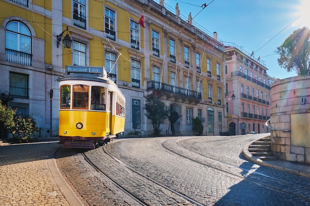 Słynny żółty tramwaj w wąskich uliczkach dzielnicy alfama w portugalii w lizbonie