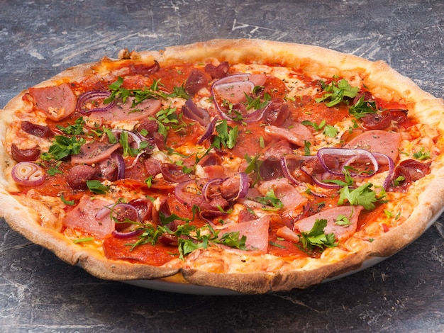 Smaczna bawarska pizza z szynką, salami, wędzoną kiełbasą