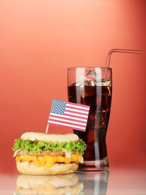 Zdjęcie smaczna kanapka z amerykańską flagą i colą na czerwonym tle