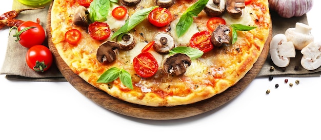 Smaczna pizza i świeże warzywa na okrągłej drewnianej desce z bliska