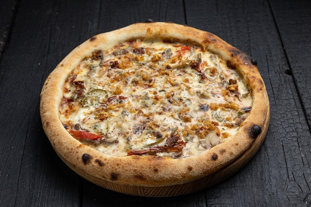 smaczna pizza z serem i warzywami na drewnianym ciemnym stole