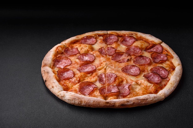 Smaczna świeża pizza z salami, pomidorami, przyprawami i solą