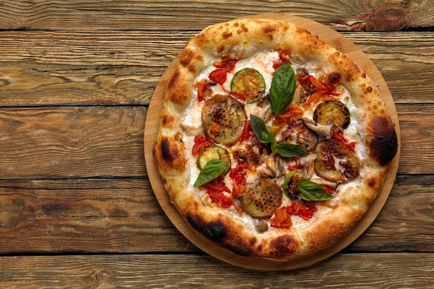 Smaczna wegetariańska pizza z warzywami sos pomidorowy papier ser zioła i bazylia Tradycyjne włoskie jedzenie na desce na drewnianym tle Koncepcja dostawy żywności