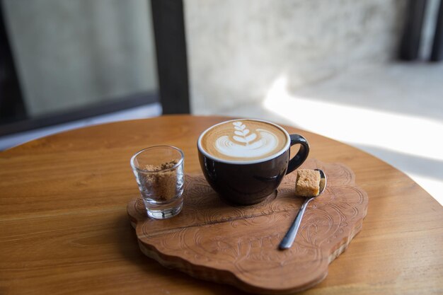 Smaczne cappuccino z piękną latte art na drewnianym stole w kawiarni