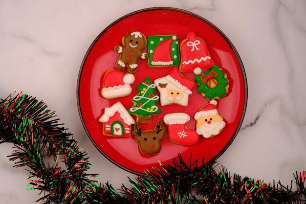 smaczne ciasteczka świąteczne na czerwonym talerzu ceramicznym. pyszne kolorowe ciasteczka świąteczne. Wesołych Świąt.
