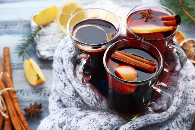 Smaczne grzane wino i przyprawy, na niebieskim tle drewnianych, zbliżenie