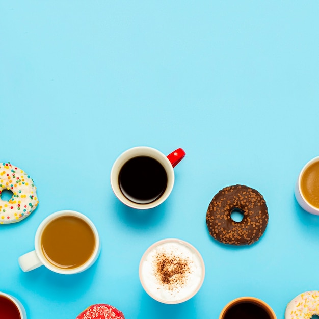 Smaczne Pączki I Filiżanki Z Gorącymi Napojami, Kawą, Cappuccino, Herbatą Na Niebiesko