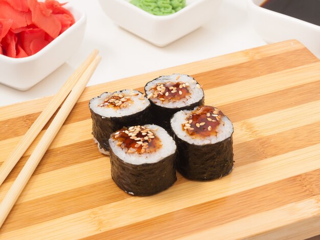 Smaczne sushi roll z węgorzem w wodorostach nori na drewnianej desce