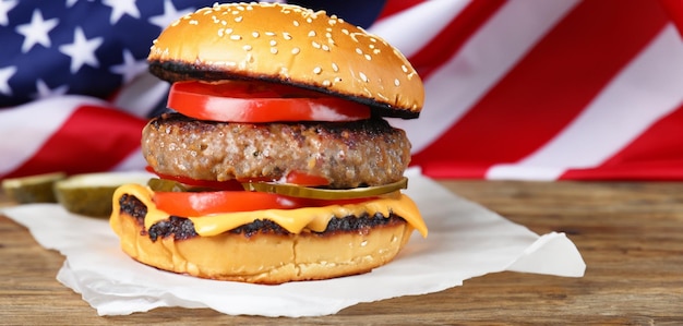 Smaczny burger z amerykańską flagą na drewnianym stole