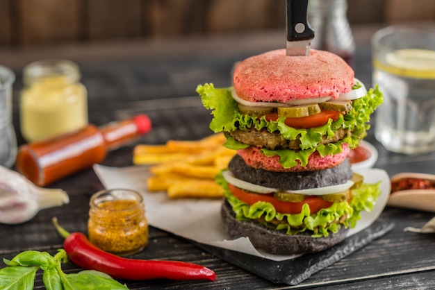 Smaczny hamburger z mięsem i warzywami na ciemnym tle. Fast food. Może być używany jako tło