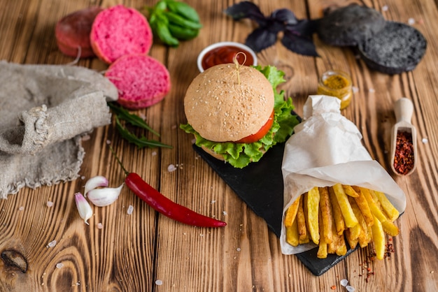 Smaczny hamburger z mięsem i warzywami na ciemnym tle. Fast food. Może być używany jako tło