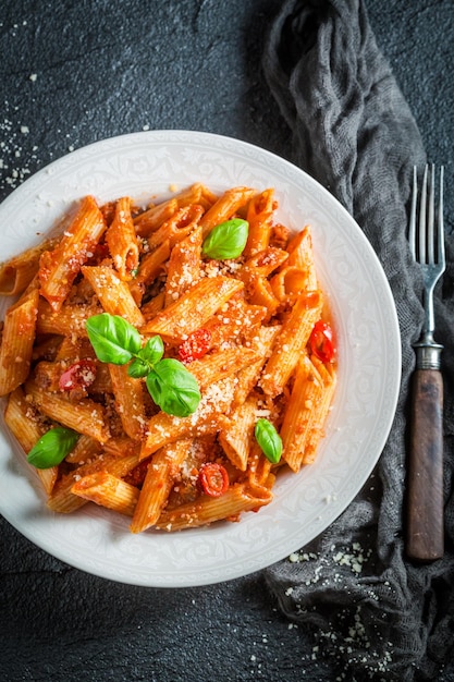 Smaczny makaron bolognese z parmezanem i bazylią