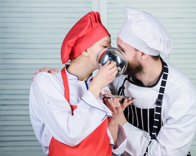 Smaczny pocałunek Rodzinne gotowanie w kuchni tajny składnik według przepisu mundur kucharza mężczyzna i kobieta szef kuchni w restauracji para zakochana w doskonałym jedzeniu planowanie menu kuchnia kulinarna miłość do gotowania