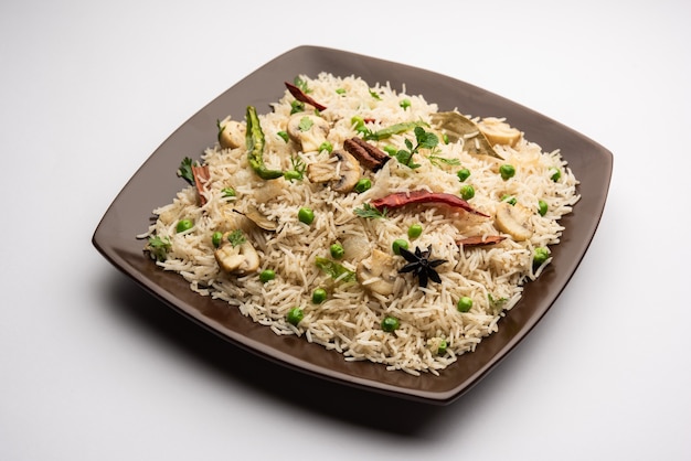 Smaczny Ryż Grzybowy lub Grzybowy lub Pulav lub Pilaf lub Pulao lub Biryani podawany w misce lub talerzu, selektywne skupienie