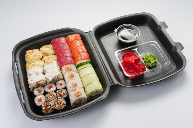 Zdjęcie smaczny zestaw rolek sushi w ciemnych pudełkach koncepcja dostawy żywności