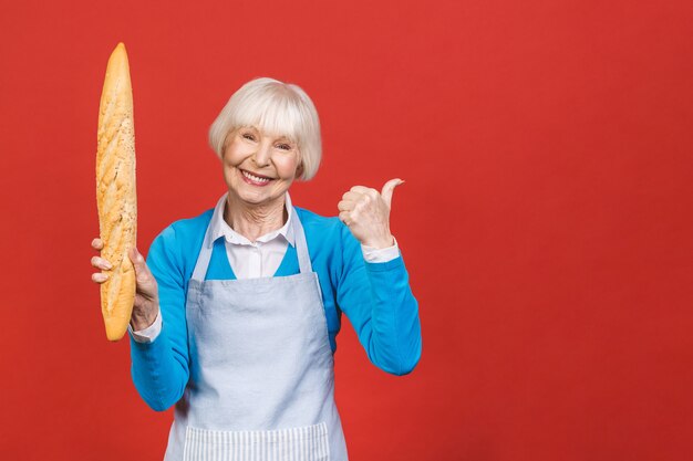 Smak Francji. Portret radosna starsza kobieta trzyma świeżego wyśmienicie chlebowego baguette