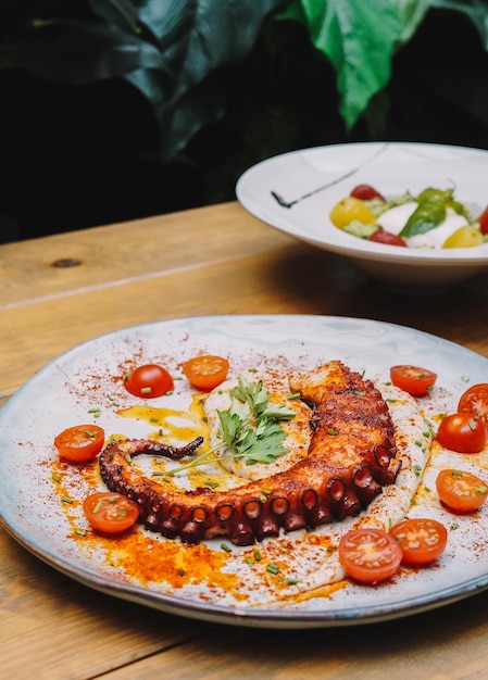 Smakosz macek ośmiornicy serwujący dania we francuskiej restauracji.