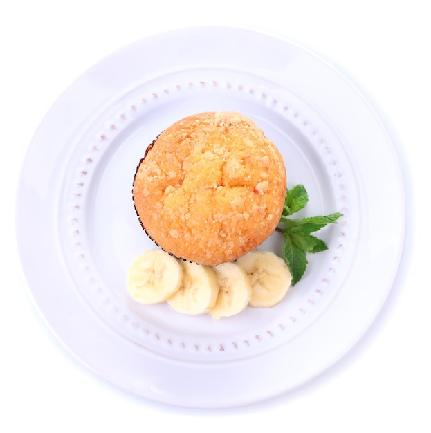 Smakowity bananowy muffin na talerzu odizolowywającym na bielu