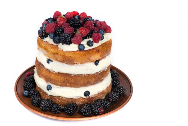 Zdjęcie smakowity tort z truskawką, malinką i czernicą odizolowywającymi na bielu