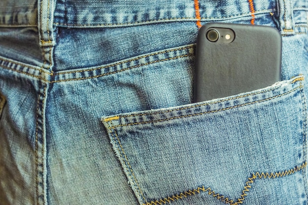 smartfon w tylnej kieszeni dżinsów z bliska