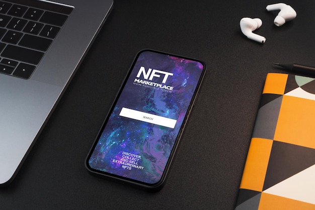 Smartfon z NFT NonFungible Token Marketplace na ekranie na stole z czarnym tłem Środowisko biurowe Crypto art