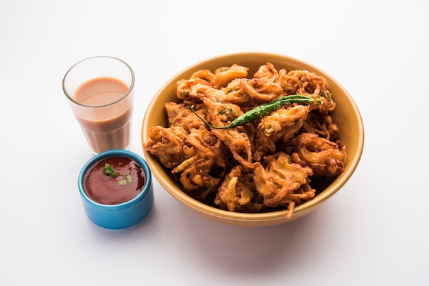 Smażona cebulowa pakora lub Pyaj Pakoda znana również jako Crispy Kanda bhaji /Bhajji / bajji, ulubiona indyjska przekąska Tea-Time w porze deszczowej. podawany z ketchupem