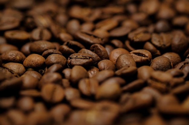 Smażona kawa na drewniane tło grunge. Ziarna kawy brązowe, zbliżenie ziaren kawy dla tekstury, makro w tle. Kawa, tekstura tło, makro. Zdjęcia wysokiej jakości