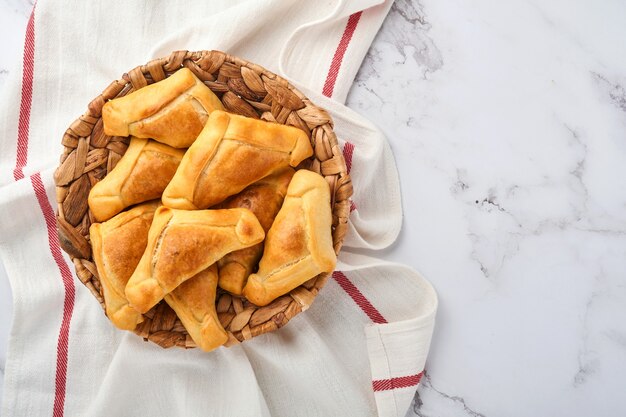 Smażone empanady z kolendrą, mięsem, jajkiem, pomidorem i sosem chili na białym tle. Koncepcja dzień niepodległości Ameryki Łacińskiej i Chile.