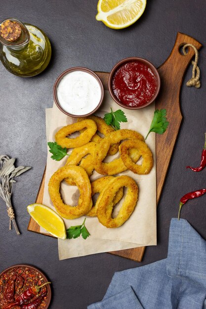 Smażone krążki kalmarów z dwoma sosami, cytryną i ziołami. Fast food. Przystawka.