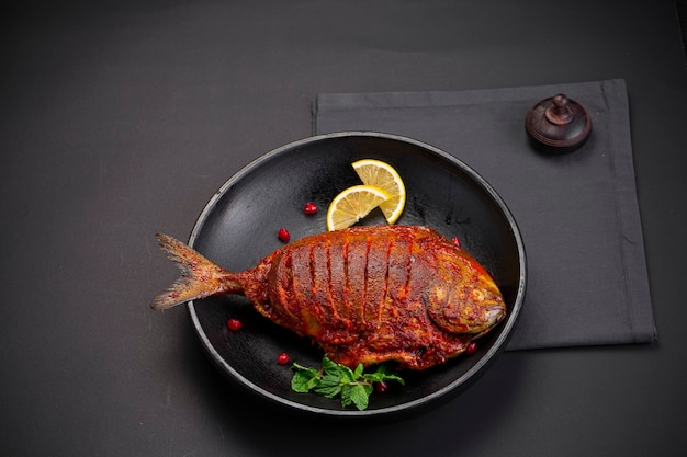 Smażone ryby Smażone Pomfret przybrane liściem kolendry i plasterkami cytryny
